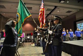Female Honor Guard and woman veteran saluting flag