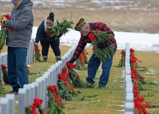VFW Member laying a wreath on a graves